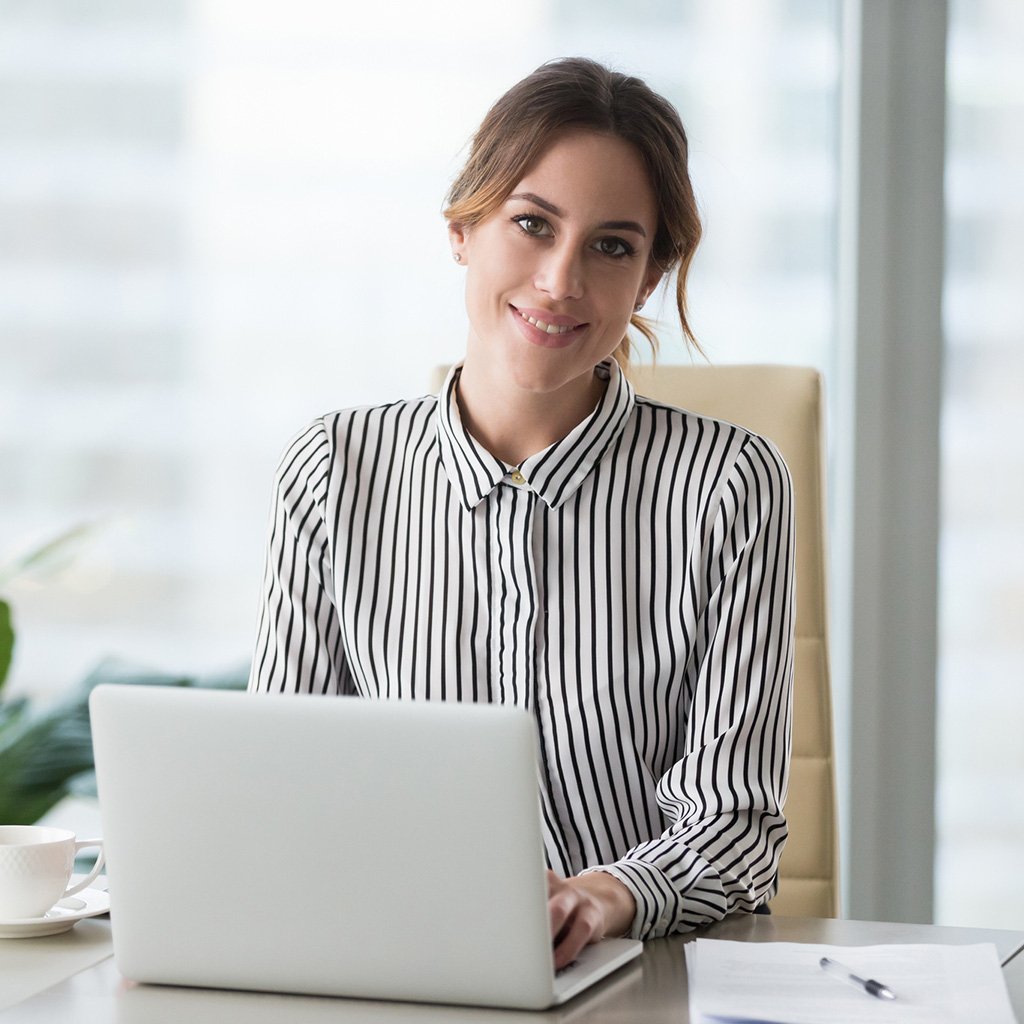 Smiling woman at her workplace is confident about Tharwatalwatan's business life insurance plans
